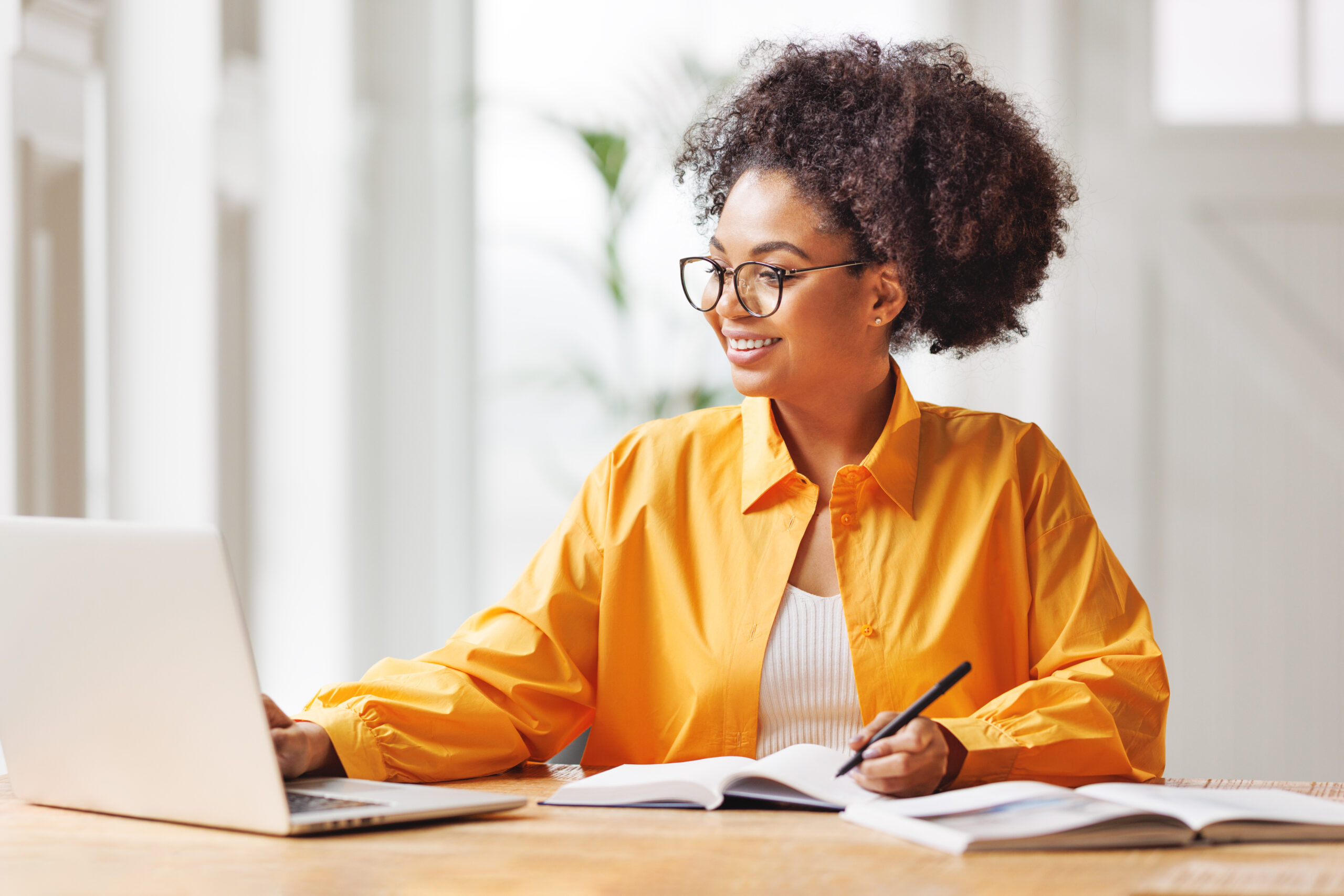 beautiful smiling african american woman works remotely on laptop from home