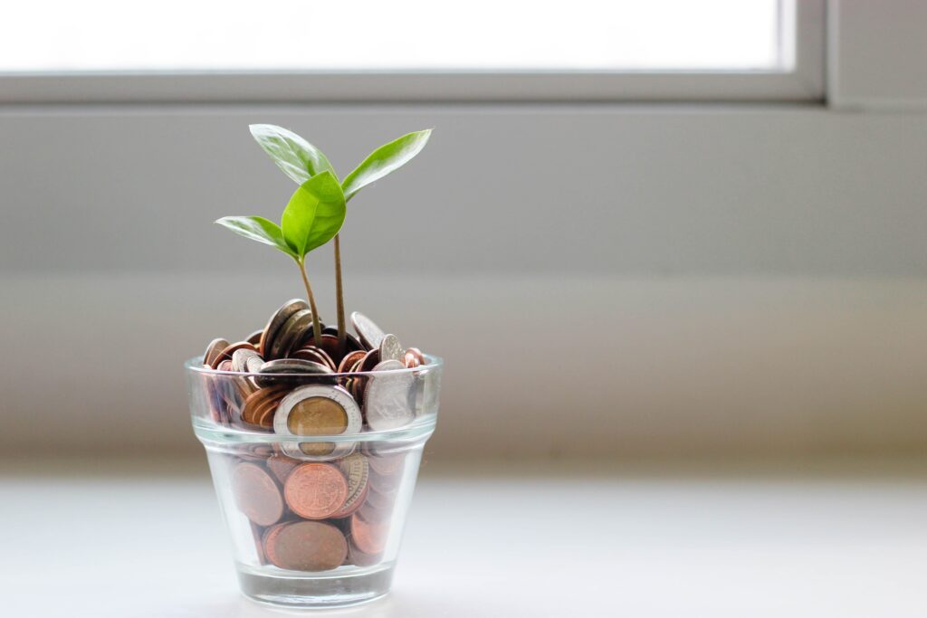 coins in a small jar with a small leaf