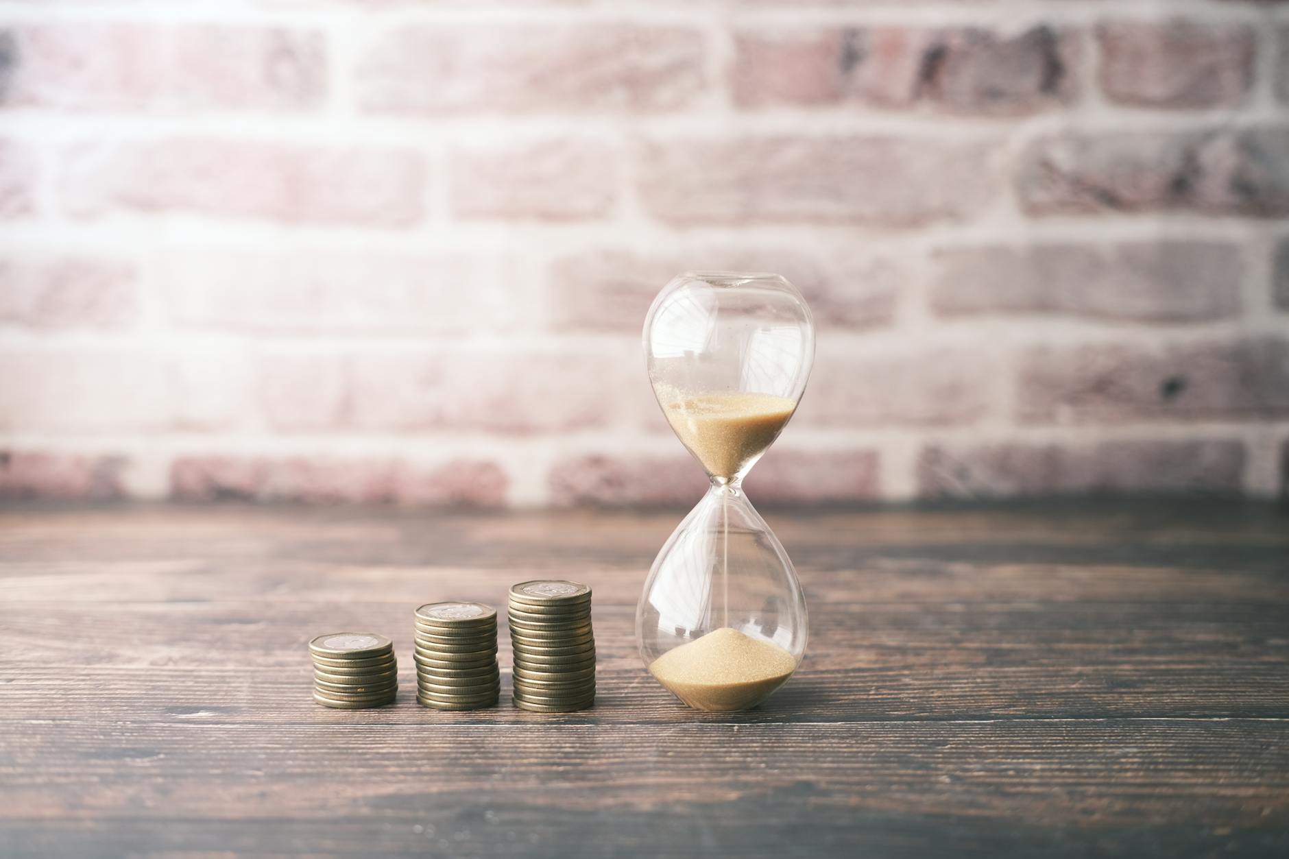 photograph of stacks of coins near an hourglass for urgent cash loans