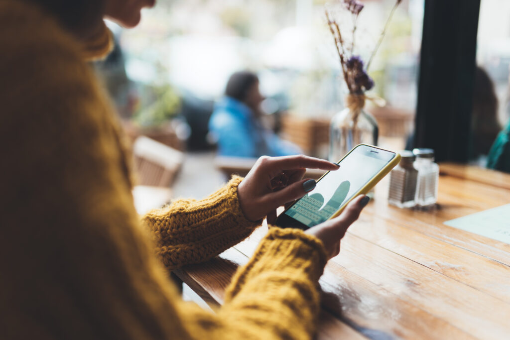 person holding a mobile phone and touching the screen