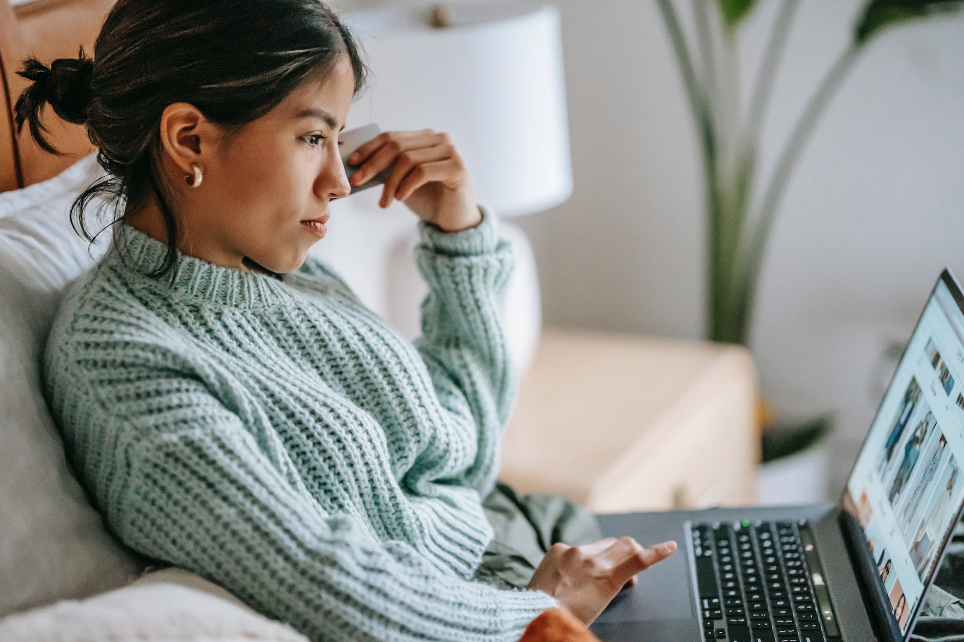 focused young woman with credit card and laptop