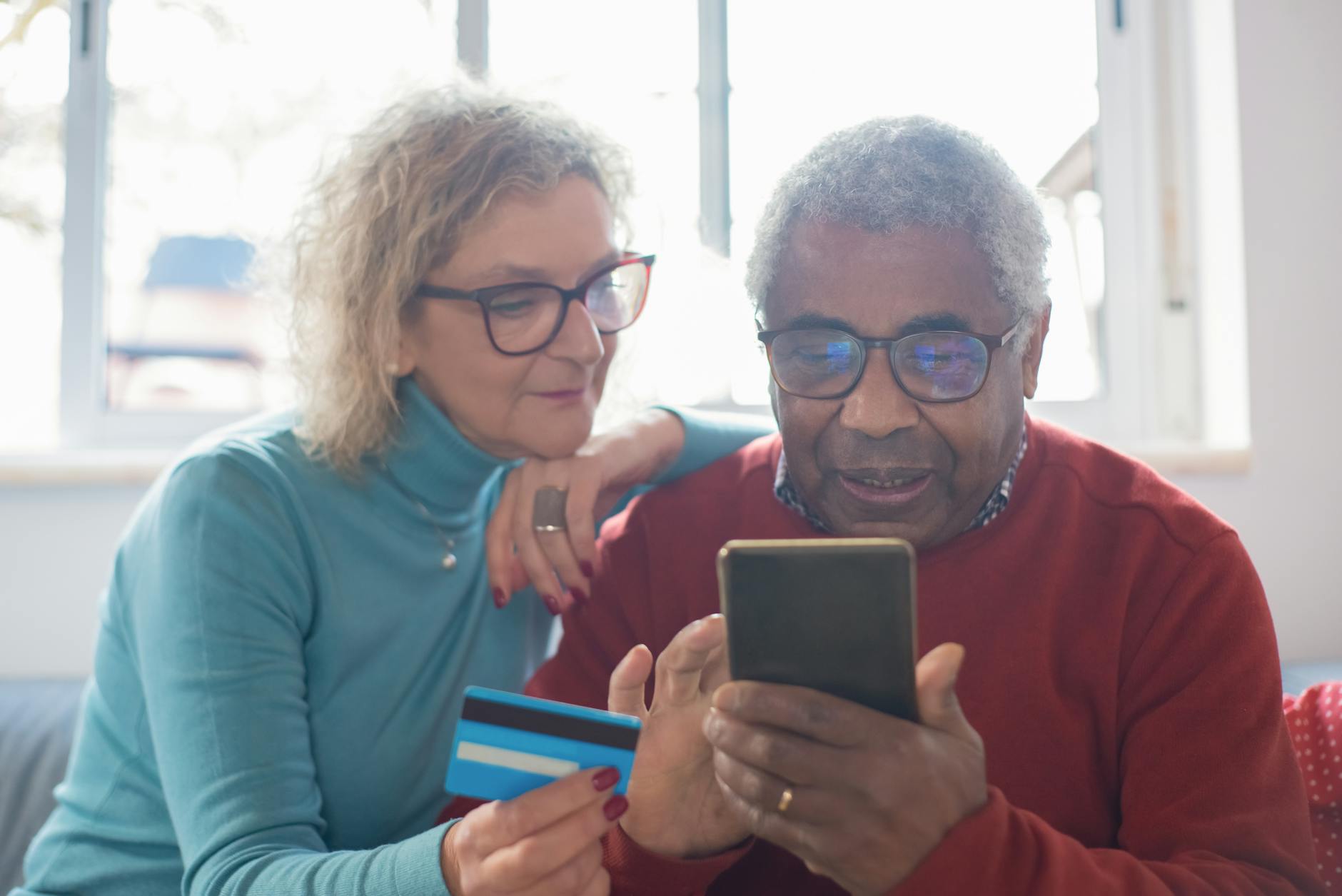 an elderly couple shopping online and using a credit card